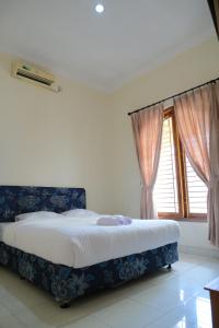 Un dormitorio con una cama y una ventana con cortinas. en New Amandani House by Yurooms, en Kejayan