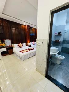 Sapphire Hotel Hue في هوى: غرفه فندقيه بسرير ومرحاض