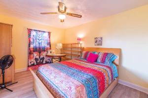 a bedroom with a bed and a ceiling fan at Boho Cocoa Beach 1BR Steps to Beach in Cape Canaveral