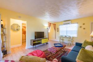 a living room with a blue couch and a tv at Boho Cocoa Beach 1BR Steps to Beach in Cape Canaveral