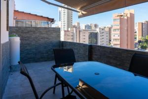 a balcony with a blue table and chairs on a building at Apartalux Ático Jaime I in Benidorm