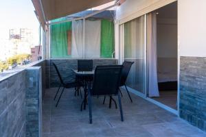 a patio with chairs and a table on a balcony at Apartalux Ático Jaime I in Benidorm