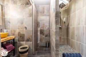 una ducha con puerta de cristal en un baño en Chambres D'hôtes Histoire D'anges, en Joursac 45 fotos más