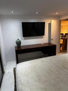 a bedroom with a desk with a television on a wall at Enigma in José Ignacio