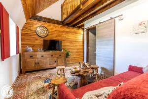 Una sala de estar con un sofá rojo y un televisor. en Chambres D'hôtes Histoire D'anges, en Joursac