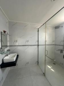 a white bathroom with a sink and a shower at Cao Lanh Hotel in Ấp Mỹ Ðông