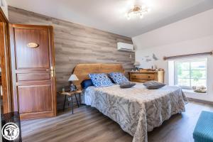 Un dormitorio con una cama y una pared de madera. en Chambres D'hôtes Histoire D'anges, en Joursac