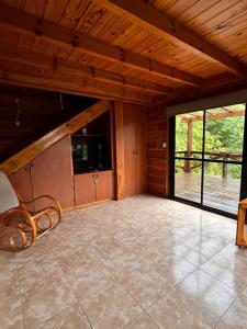 Cabaña Alpina con Terraza Panorámica في لا كومبريسيتا: غرفة فارغة بها مقعد وشرفة