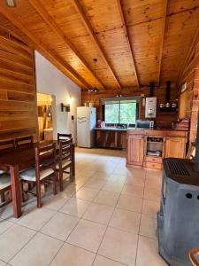 Cabaña Alpina con Terraza Panorámica في لا كومبريسيتا: مطبخ كبير بسقوف خشبية وطاولة وكراسي +16 صورة