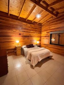 Cabaña Alpina con Terraza Panorámica في لا كومبريسيتا: غرفة نوم مع سرير في غرفة خشبية
