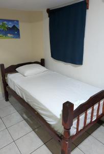 Bett in einem Zimmer mit einem blauen Vorhang in der Unterkunft Chale's House Hotel in San Juan del Sur + 21 Fotos