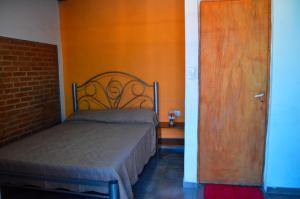 a bedroom with a bed and a wooden door at Complejo Fresia in Mina Clavero