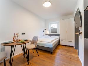 霍赫克尼希山麓丁滕Leni Top 2的一间带床和桌子的卧室和一间餐厅