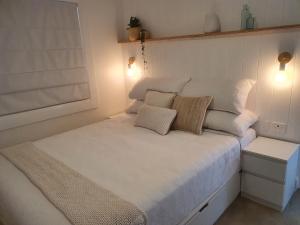a small bedroom with a white bed with two pillows at Saltwater Apartments in Lake Cathie +23 photos
