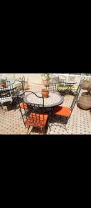 een patio met een tafel en stoelen en een tafel en stoelen bij Guests House With View Rooftop in Marrakesh +24 foto's
