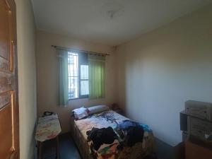 een kleine slaapkamer met een bed en een raam bij Rio Ocean View House in Ilha do Tatu