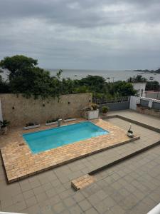 een zwembad op een patio naast de oceaan bij Rio Ocean View House in Ilha do Tatu