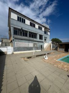 een gebouw met een zwembad ervoor bij Rio Ocean View House in Ilha do Tatu