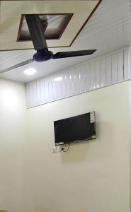 BhiwandiHotel Amrapali的壁挂式电视和吊扇