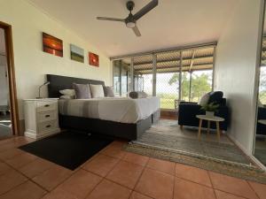 Altitude 700 Rural Retreat : غرفة نوم بها سرير ومروحة سقف