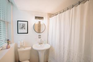 a bathroom with a sink and a white shower curtain at Hidden Escape Atlanta Near BENZ ARPT Beltline in Atlanta +8 photos