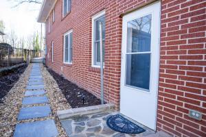 a brick building with a white door and a sidewalk at Hidden Escape Atlanta Near BENZ ARPT Beltline in Atlanta