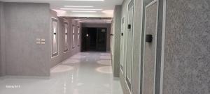 a hallway in a building with white floors and walls at غزو 15 in Aydūn