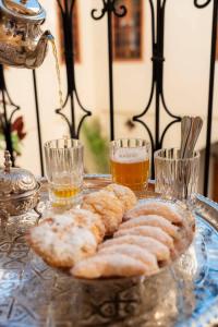 Una bandeja de pasteles y vasos de cerveza sobre una mesa. en Guests House With View Rooftop, en Marrakech