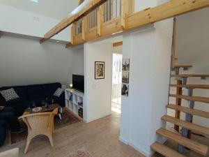 a living room with a black couch and a staircase at bi Hugo - Kiekut in Kappeln