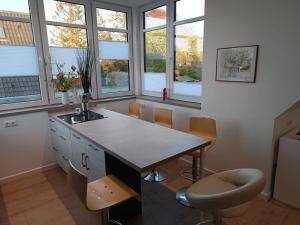 a kitchen with a table and chairs and windows at bi Hugo - Kiekut in Kappeln +22 photos