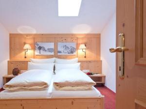 Un dormitorio con una cama grande con almohadas blancas. en Sonnblick in Huaterhof, en Laimach