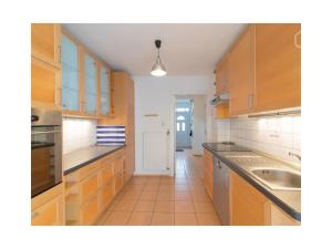 汉堡Holiday home in beautiful Hamburg的厨房配有木制橱柜和瓷砖地板。