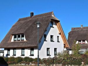 una grande casa bianca con il tetto marrone di Holiday apartment with 2 bedrooms a Hof Dranske