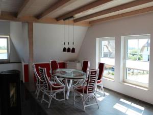 una sala da pranzo con tavolo e sedie in vetro di Holiday apartment with 2 bedrooms a Hof Dranske