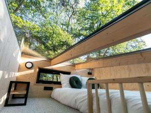 Holiday cottage in Teteringen with Wi-Fi في Teteringen: غرفة نوم في منزل شجرة مع نافذة كبيرة