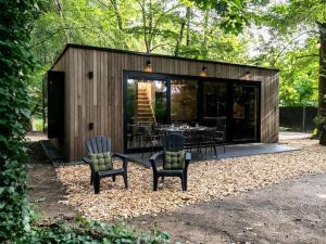 Holiday cottage in Teteringen with Wi-Fi في Teteringen: كابينة صغيرة فيها كراسي وطاولة فيها