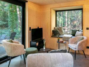 Holiday cottage in Teteringen with Wi-Fi في Teteringen: غرفة معيشة مع أريكة وكراسي وتلفزيون