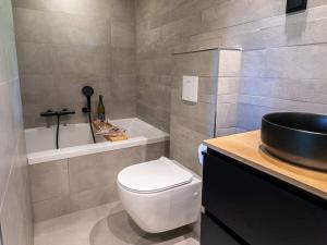 Holiday cottage in Teteringen with Wi-Fi في Teteringen: حمام مع مرحاض ومغسلة وحوض استحمام +23 صورة