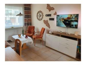a living room with a tv and a table and chairs at House Nietmann Holiday Apartment No 3 in Altenau