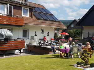 a group of people sitting at a table in a yard at House Nietmann Holiday Apartment No 3 in Altenau