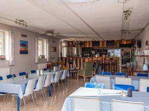 4 person holiday home in Højer في Højer: غرفة طعام مع طاولات وكراسي زرقاء