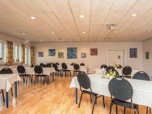 4 person holiday home in Højer في Højer: قاعة احتفالات مع طاولات وكراسي في غرفة