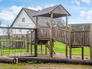 4 person holiday home in Højer في Højer: هيكل لعب خشبي أمام المنزل