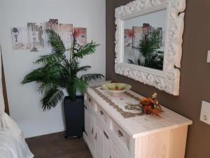 AltershausenSteigerwald Resort的梳妆台,上面有镜子和盆栽植物 更多20张照片