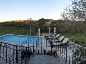 a swimming pool with a bunch of chairs next to it at Holiday home with 3 bedrooms in Ripenda Kras +21 photos