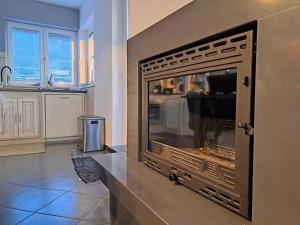 a living room with a fireplace in a kitchen at Holiday home with 3 bedrooms in Ripenda Kras