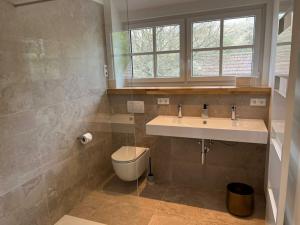 a bathroom with a sink and a toilet and a window at Holiday home in Ahorntal with swimming pool in Hinterkleebach