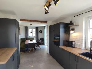 a kitchen with gray cabinets and a dining room with a table at Holiday home in Ahorntal with swimming pool in Hinterkleebach