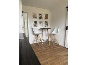 una habitación con una mesa y dos sillas blancas en Michael's Elbe Dream, en Krautsand