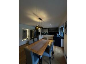 Una cocina y un comedor con mesa y sillas de madera. en Holiday apartment Robin, en Waidring